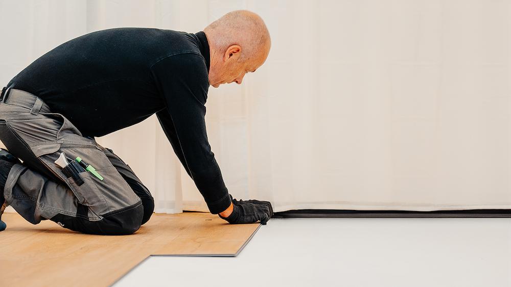 Installer connecting flooring in an official Unilin Technologies installation photograph